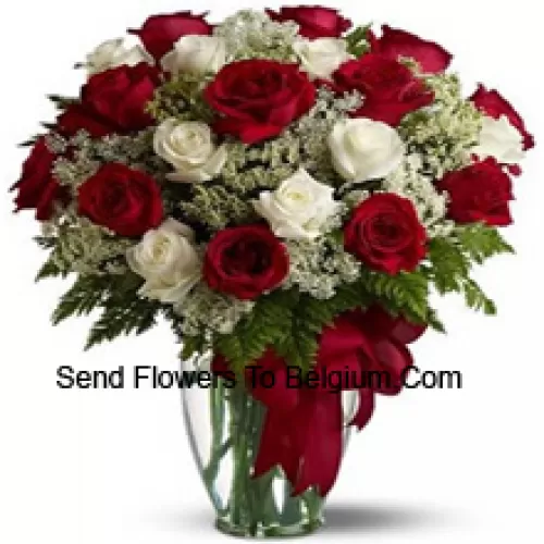 15 Red And 10 White Roses With Some Ferns In A Glass Vase
