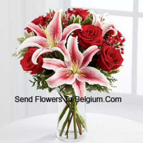 This Bouquet is a simply stunning display of seasonal glamour they won't be able to resist. Rich red roses are paired with the dazzling beauty of Stargazer lilies accented with holiday greens, berry sprays and a bordeaux satin rbbon for an elegant look. Arranged in a clear glass vase, this bouquet will add to the magic and wonder of their holiday festivities. (Please Note That We Reserve The Right To Substitute Any Product With A Suitable Product Of Equal Value In Case Of Non-Availability Of A Certain Product)